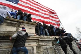 Protesters use barricades as ladders as they try to storm the US Capitol on a day where thousands of pro- Trump supporters rallied on January 6