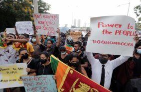 people hold placards calling for the resignation of President Gotabaya Rajapaksa